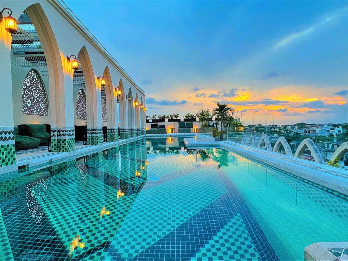 Rooftop pool under Moorish arches at sunset at Layla Tulum
