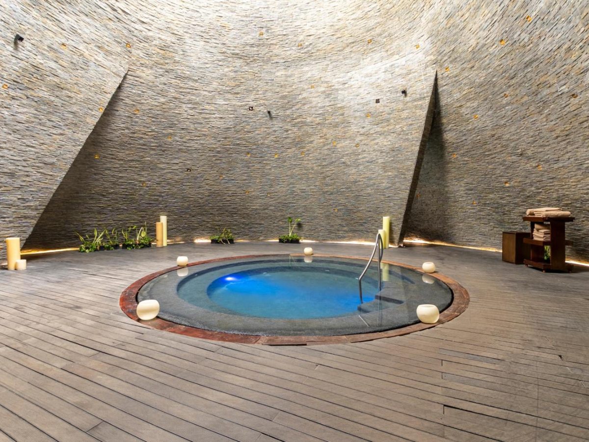 Round cenote-style pool under a stone dome in the spa at Devossion by Live Aqua