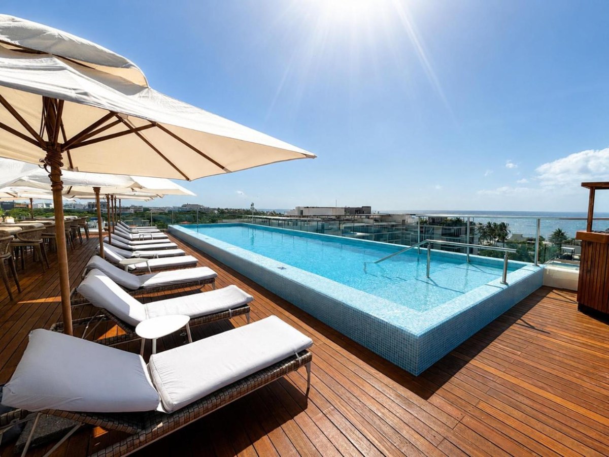 Rooftop pool with loungers and a parasol at The Reef 28