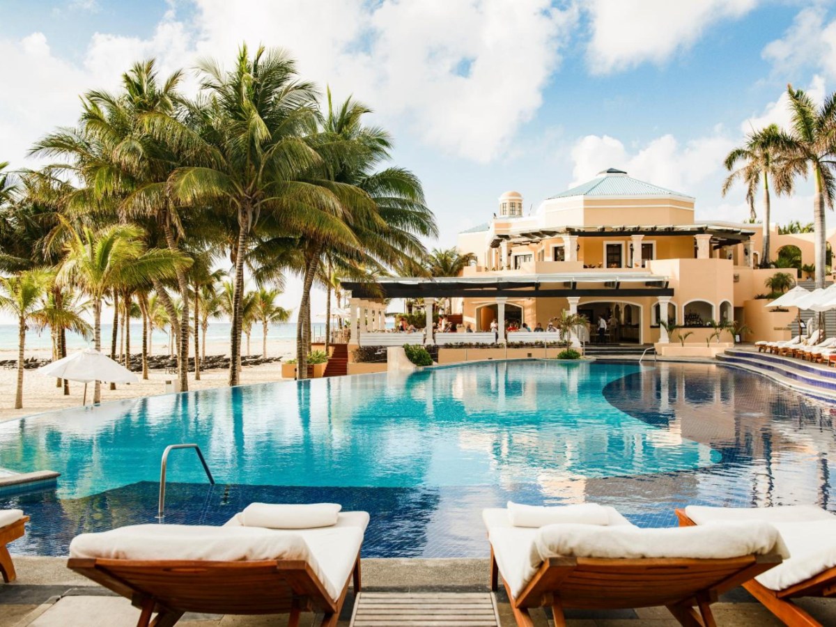 Infinity-edge pool with daybeds below the colonial-style villas at Royal Hideaway Playacar