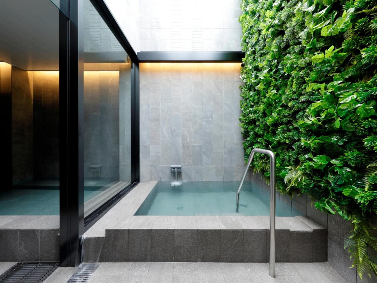 Open-air bath beside a living green wall under open sky at hotel androoms Nagoya Sakae