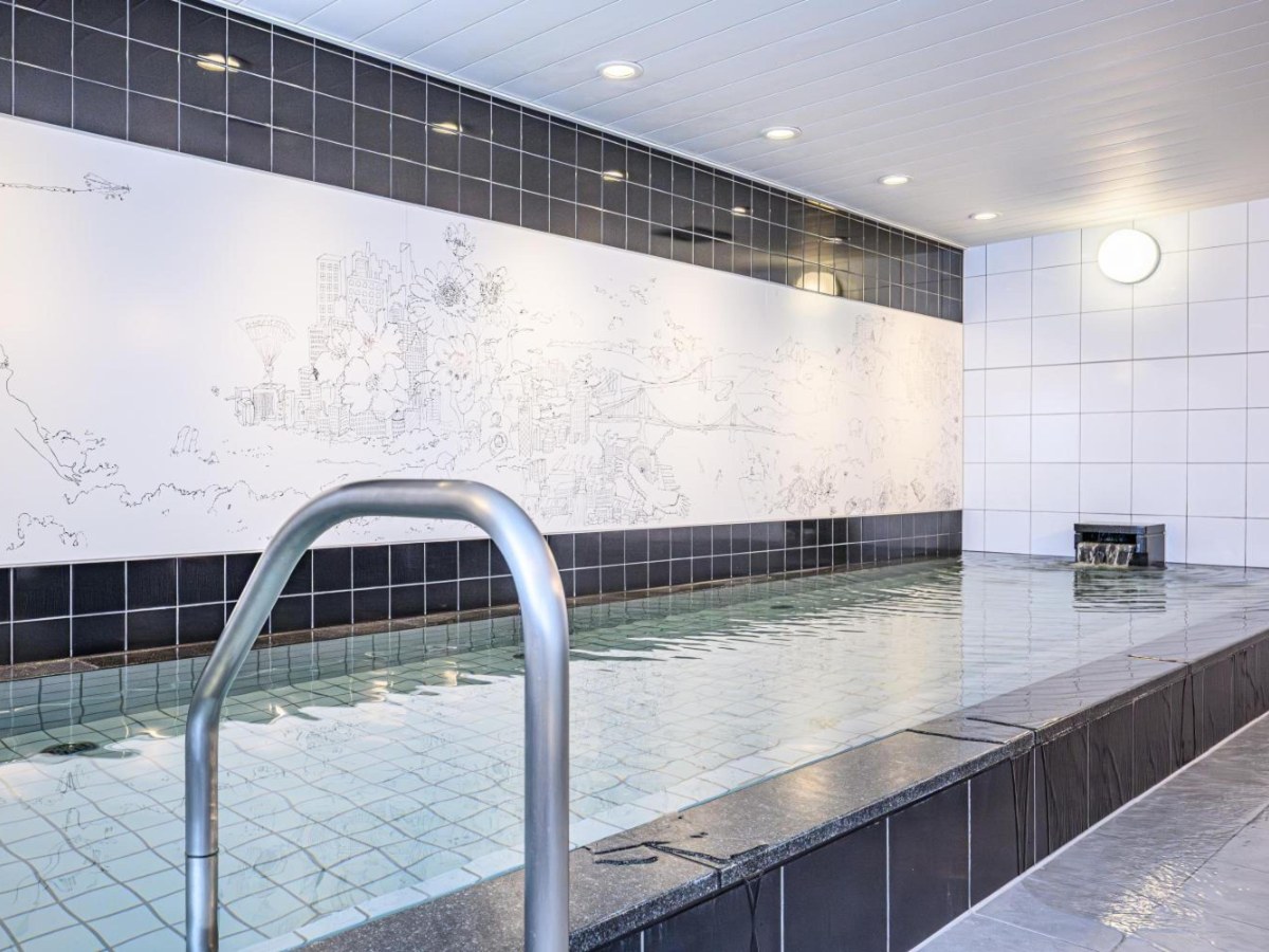 Long tiled public bath with a mural wall at The Royal Park Canvas Nagoya