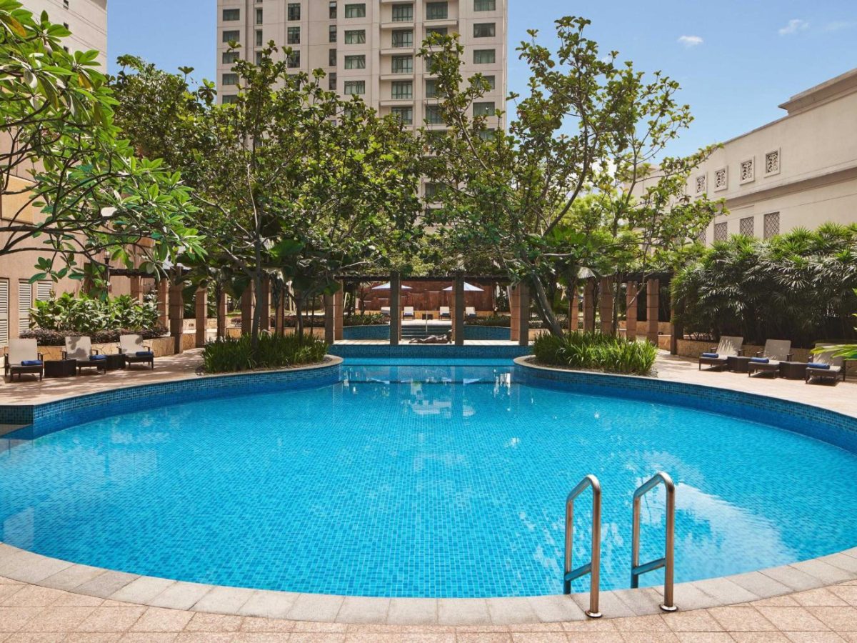 Round blue pool ringed by trees at The Westin Kuala Lumpur