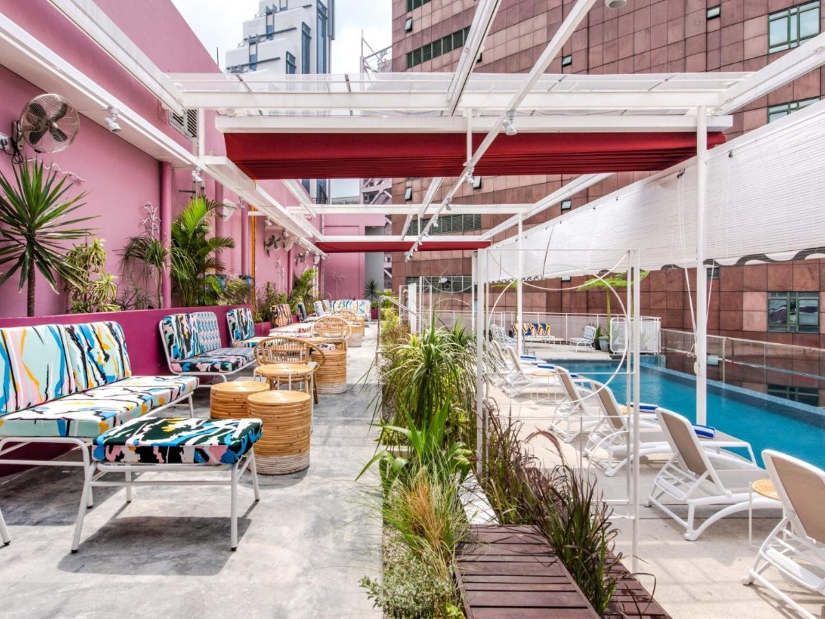 Rooftop terrace with loungers beside the pool at The Kuala Lumpur Journal Hotel