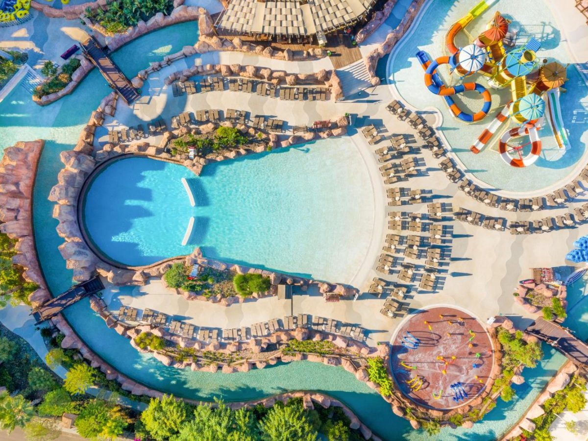 Aerial view of pools, a lazy river and a kids' slide tower at The Land of Legends, beside the Kingdom Hotel