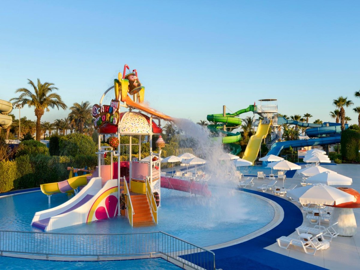 Kids' slide tower in the splash pool, with bigger slides behind, at Miracle Resort Hotel