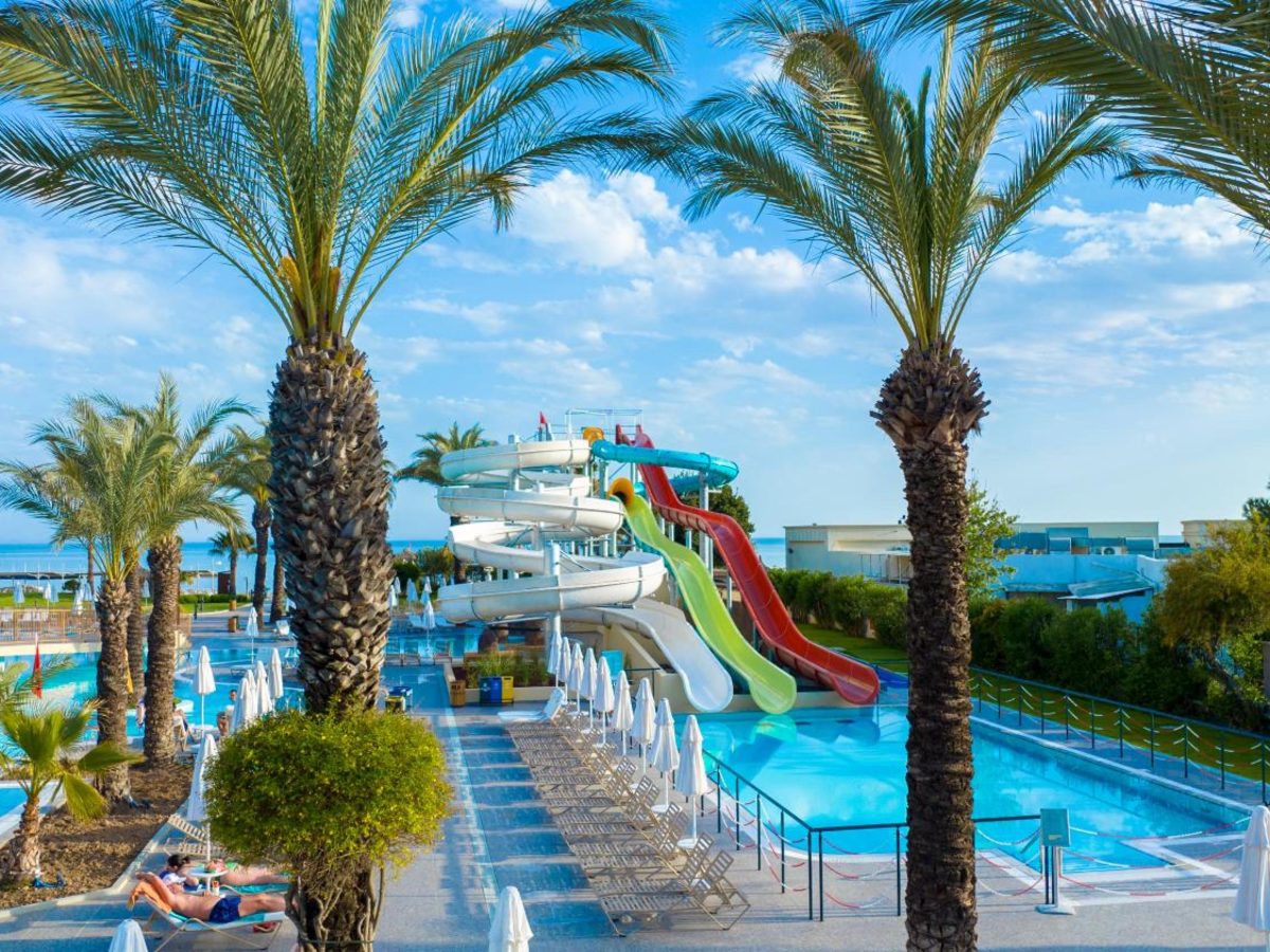 Twisting water slides behind palms at Liberty Hotels Lara