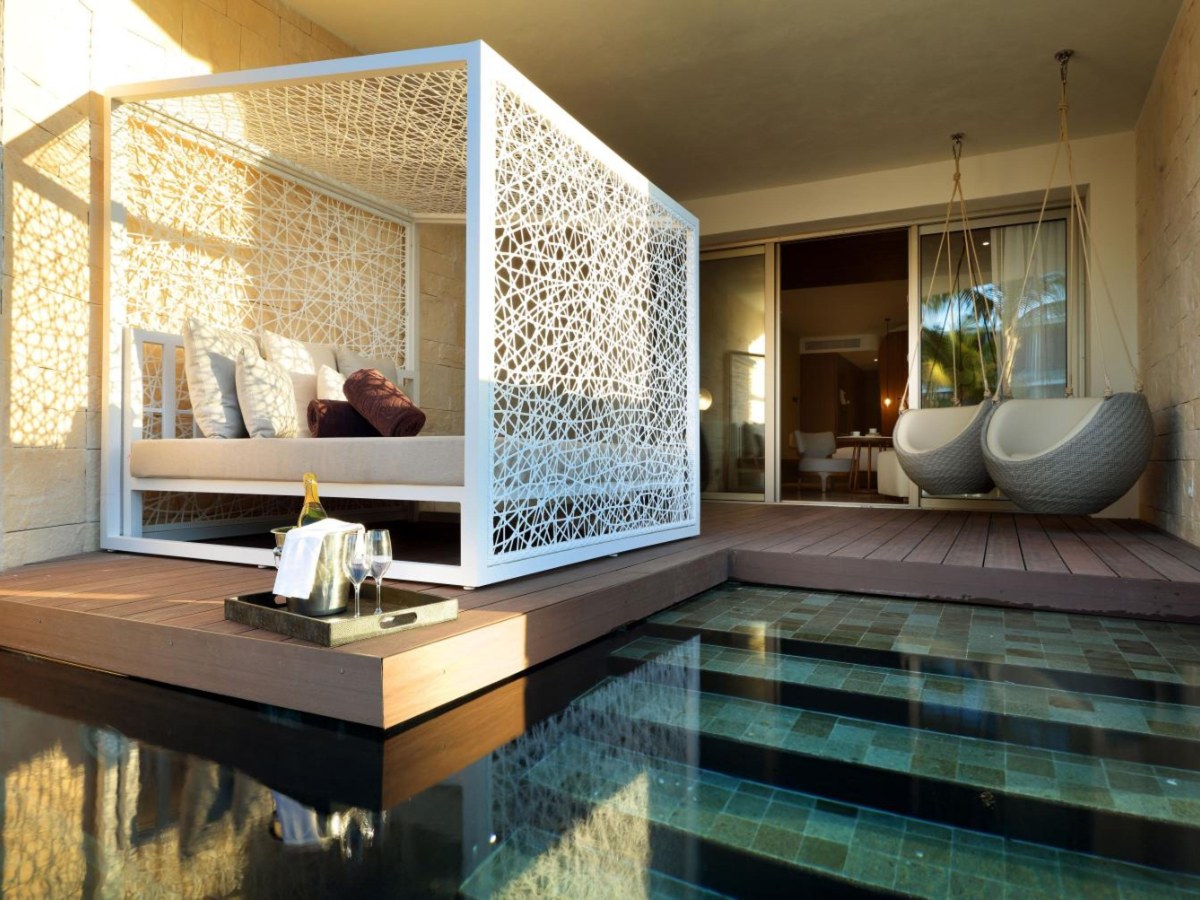 Swim-out terrace with a Balinese bed and pool steps at TRS Coral Hotel
