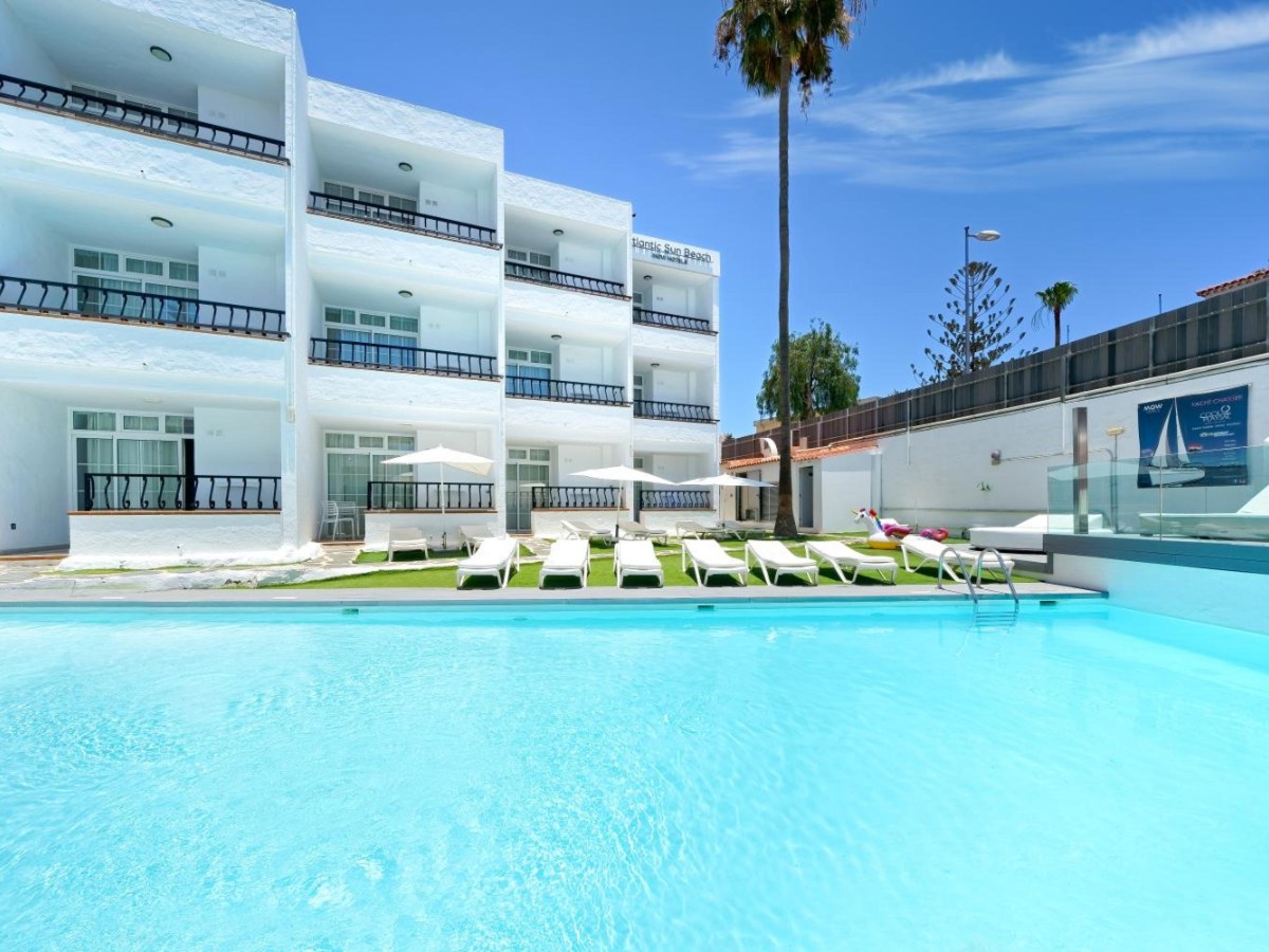 Pool and lawn loungers in front of the apartment balconies at Atlantic Sun Beach