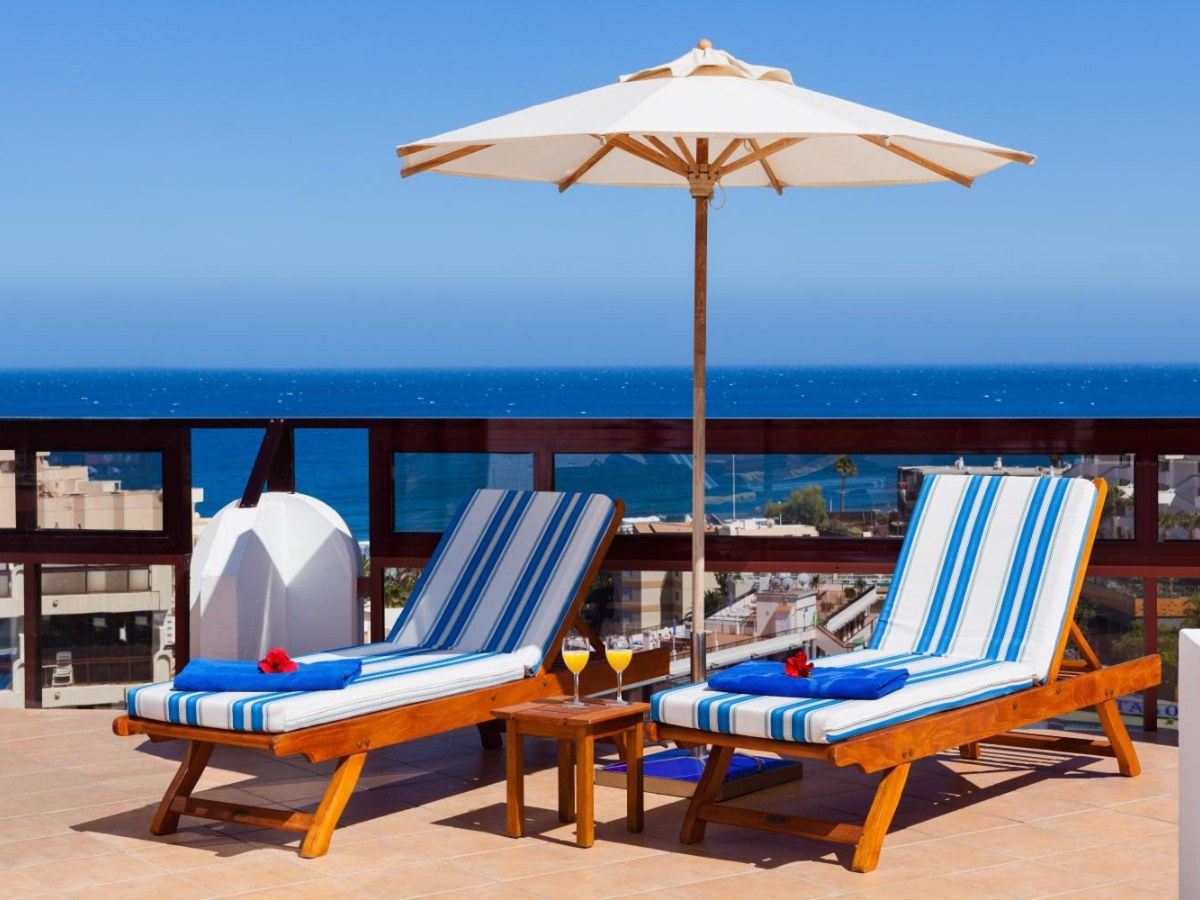 Sun terrace with striped loungers facing the sea at Seaside Sandy Beach, Playa del Inglés