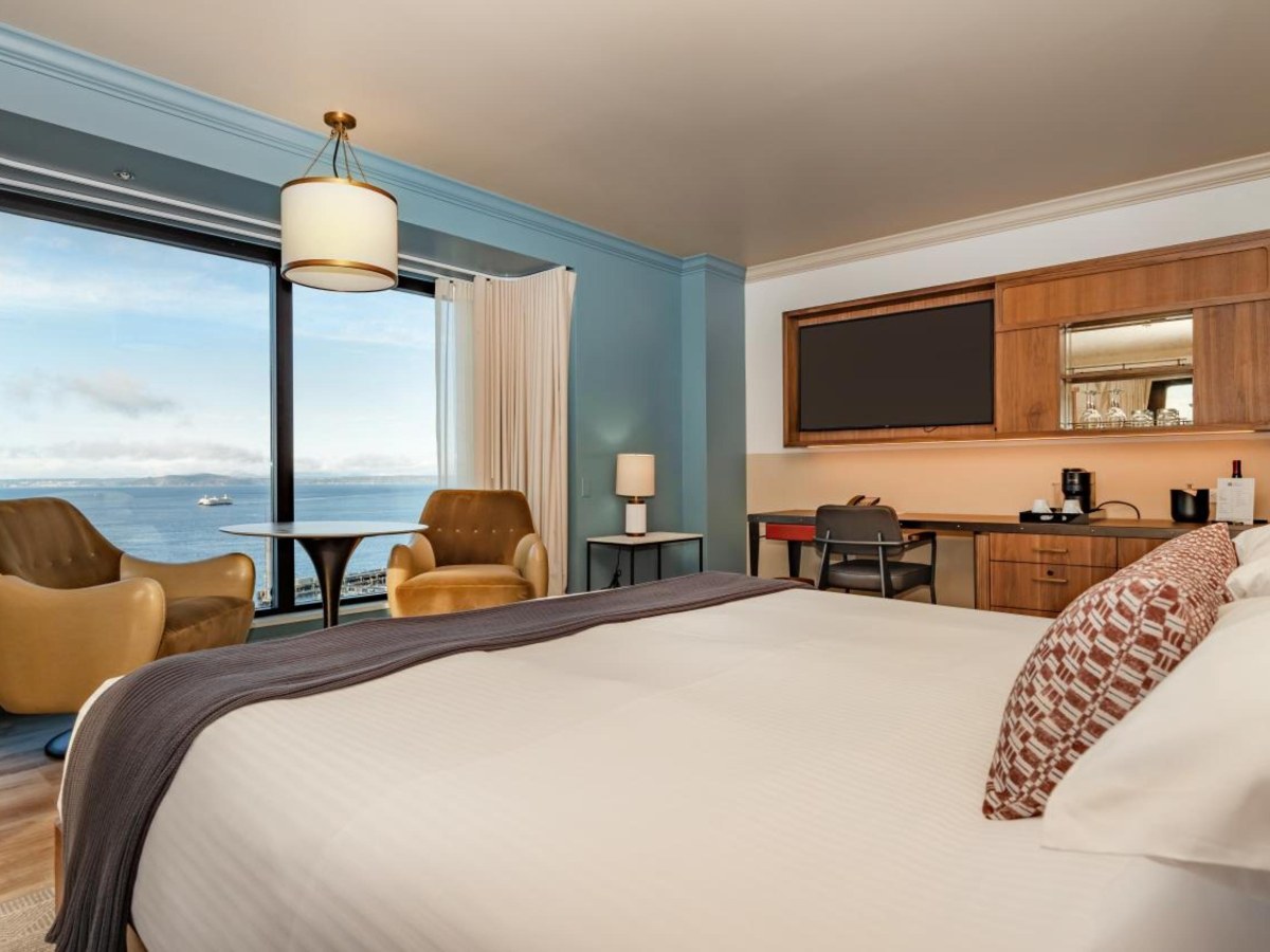 Pike Place Waterview room with a bed and a large window at Inn at the Market