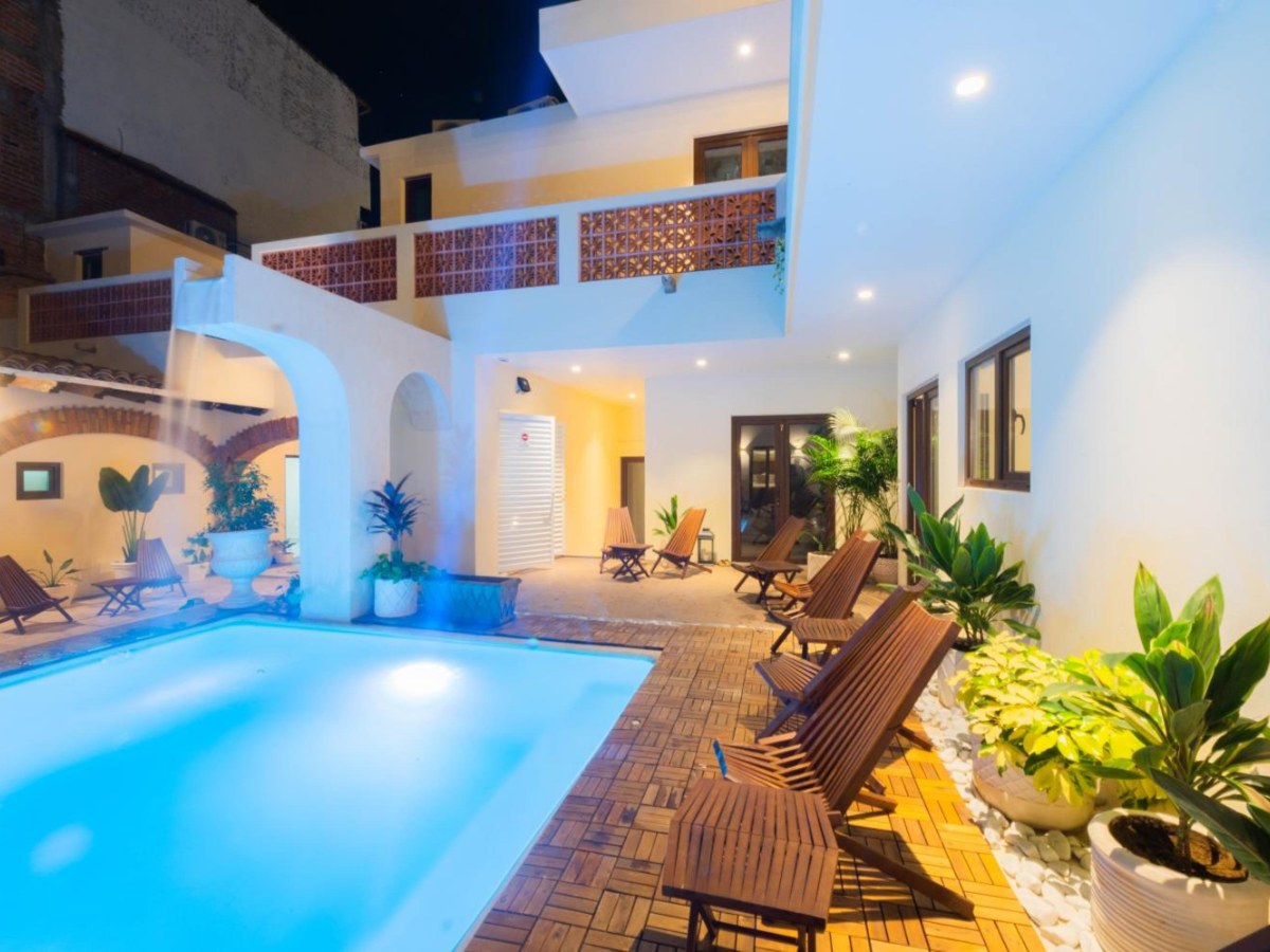 Courtyard pool lit at dusk at Casa Victoria Malecon