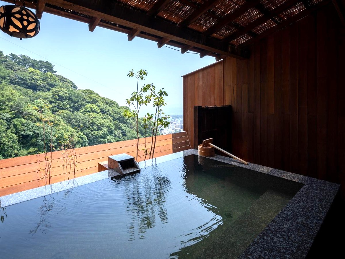 Private open-air bath above a forested slope in a Watei Kazekomichi suite