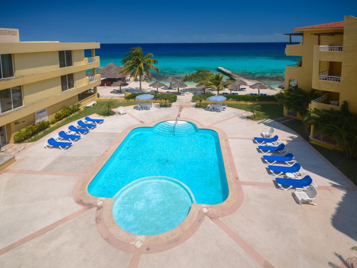 Outdoor pool with sun loungers at Playa Azul Cozumel