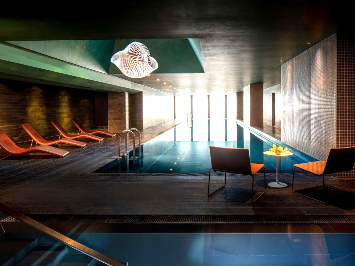Indoor infinity pool with loungers in the spa at Anantara The Marker Dublin Hotel