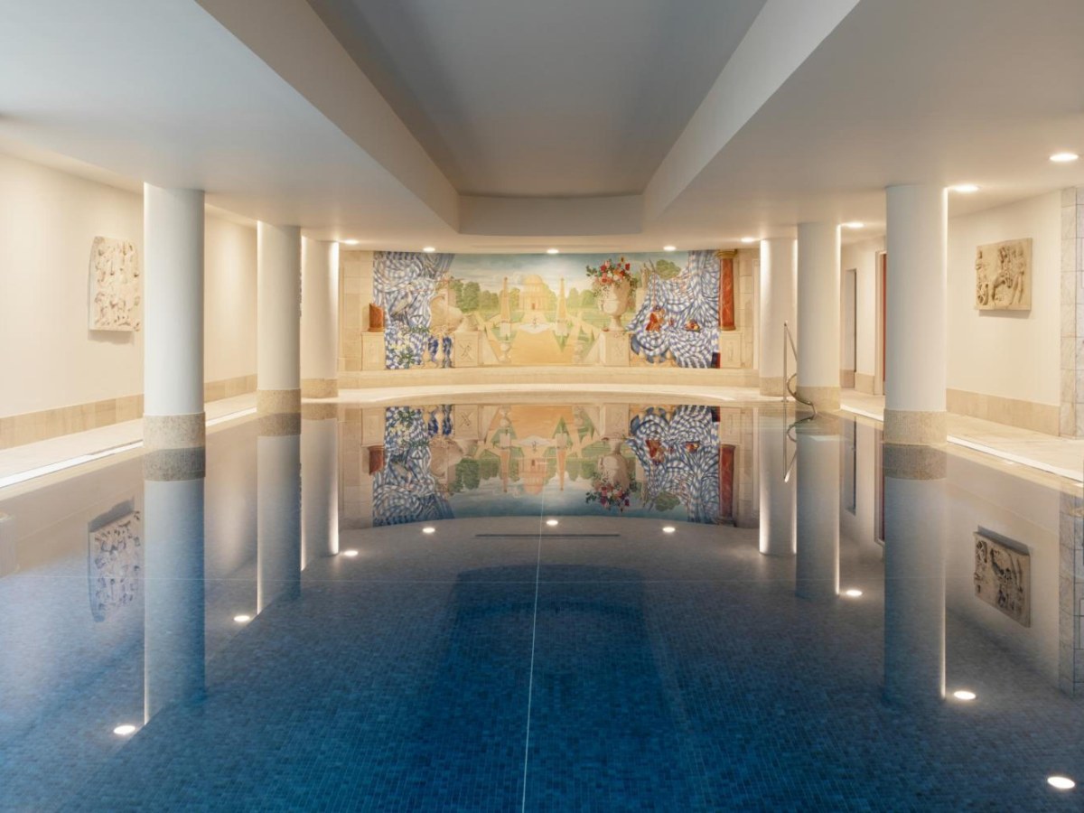 Limestone-lined indoor pool with a painted landscape mural at The Merrion Hotel