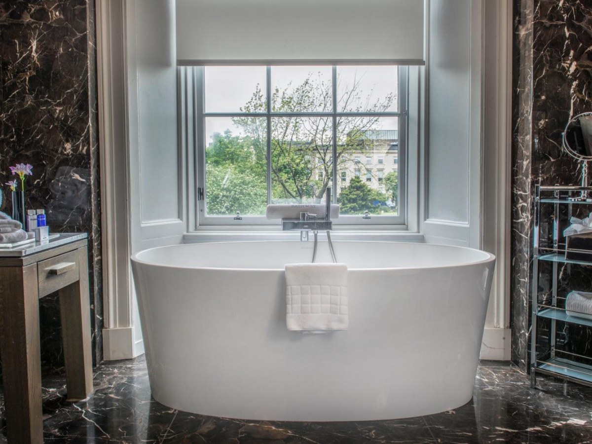 Freestanding bath by a tall window in the King Suite at Kimpton Blythswood Square