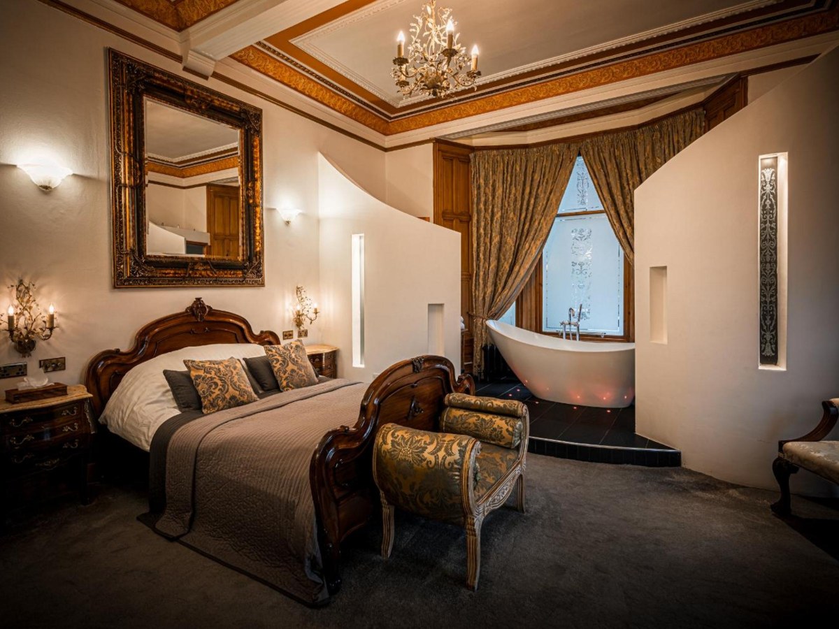 Freestanding bath by the window in the Signature Suite bedroom at The Alamo Guest House