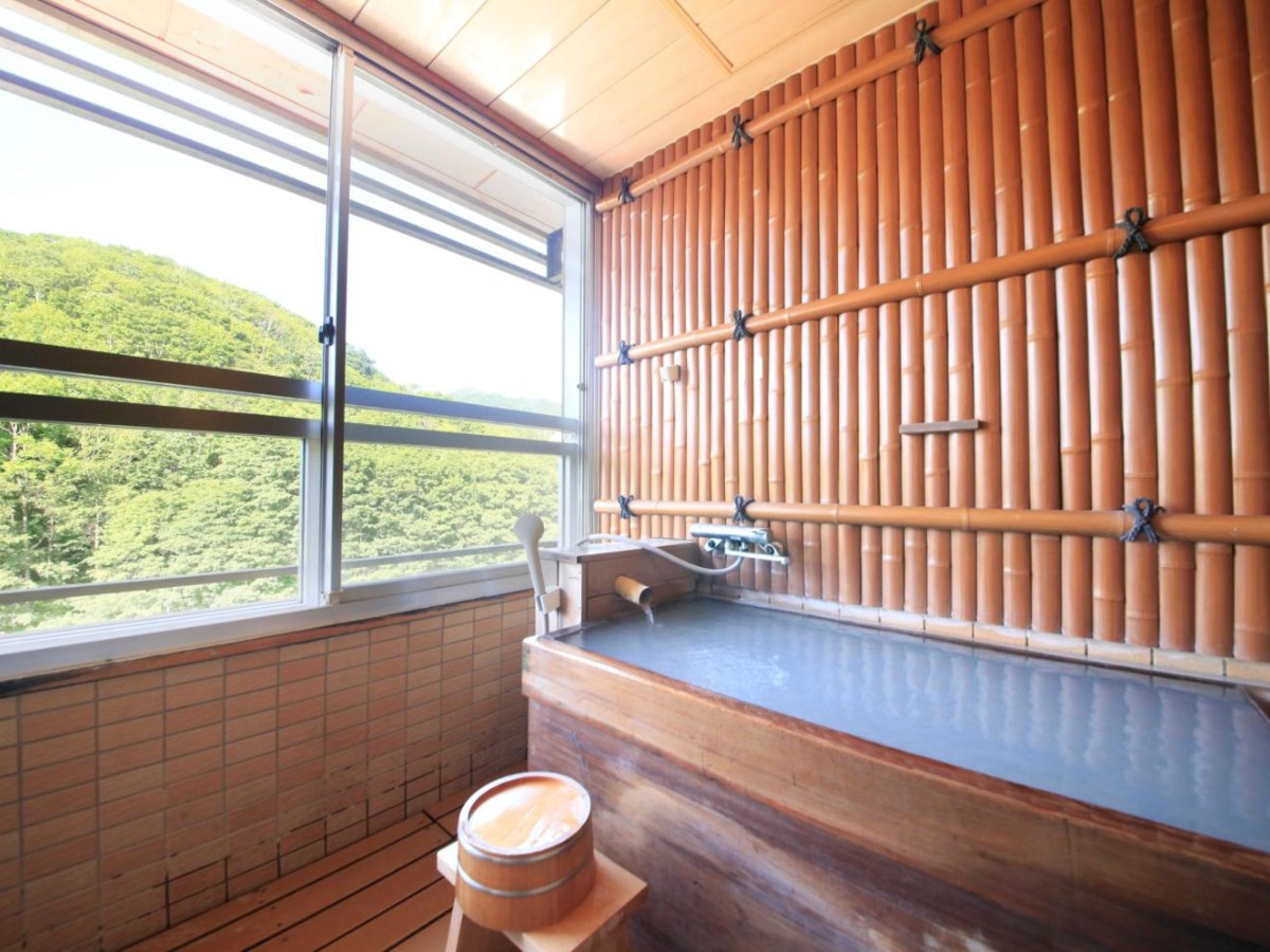 Wooden open-air bath in a room at Ryotei Hanayura