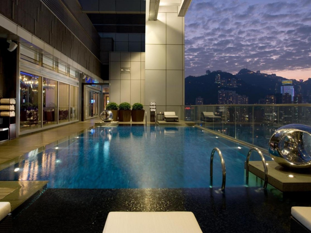 Crowne Plaza Hong Kong Causeway Bay rooftop pool at dusk with the city behind it