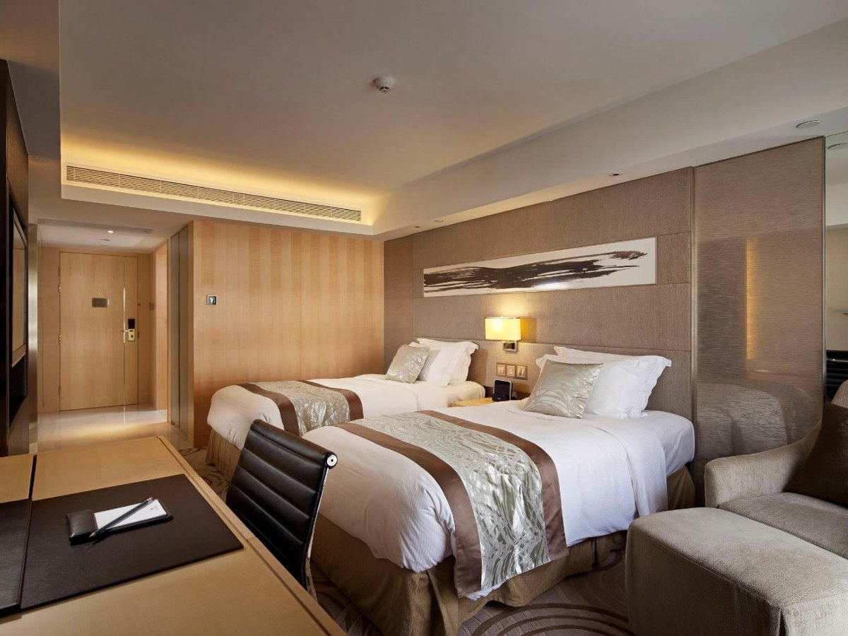 Deluxe Family Room with beds and a seating area at The Royal Garden Tsim Sha Tsui