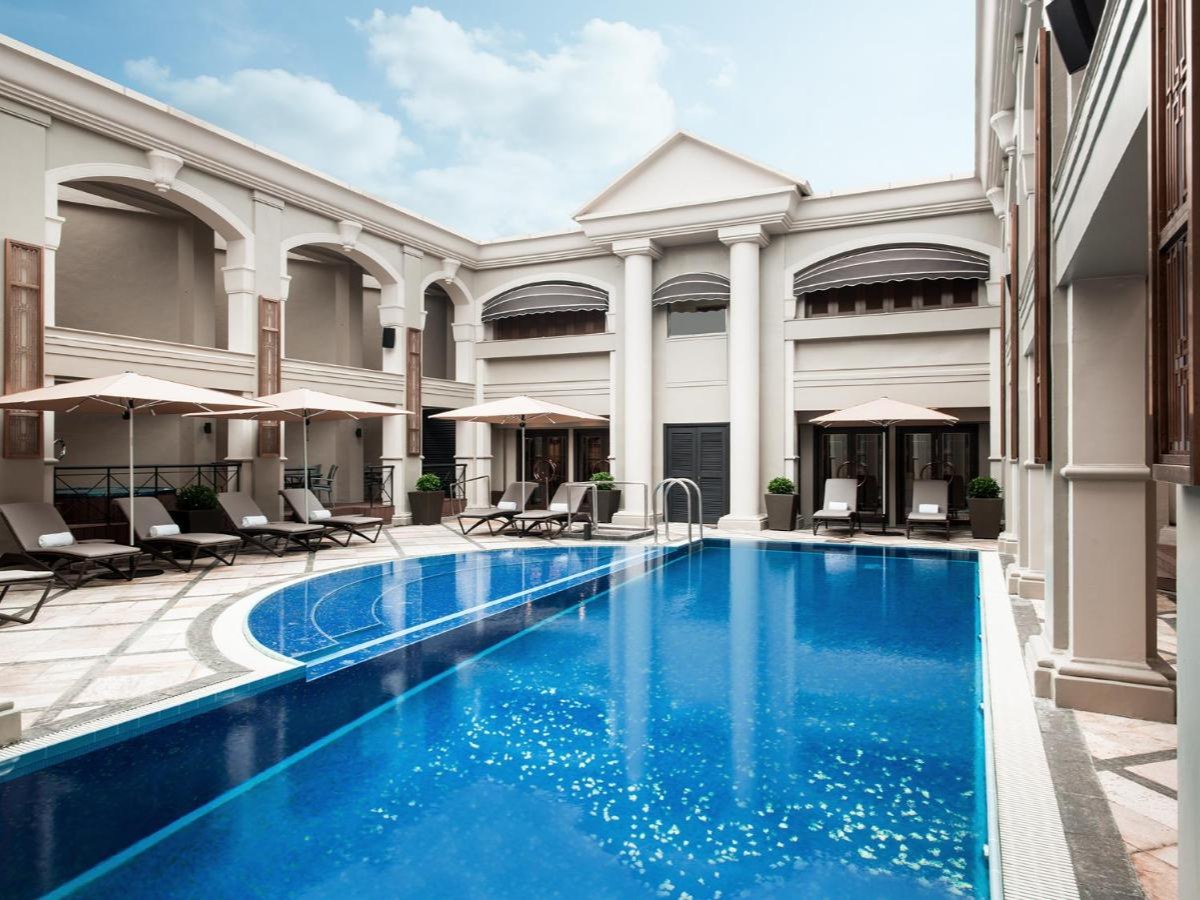 The Langham Hong Kong heated pool on Level 15 with loungers and a colonnaded courtyard
