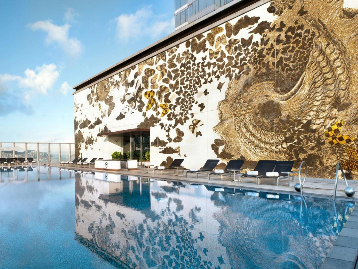 W Hong Kong rooftop pool with a mural wall and the skyline behind it