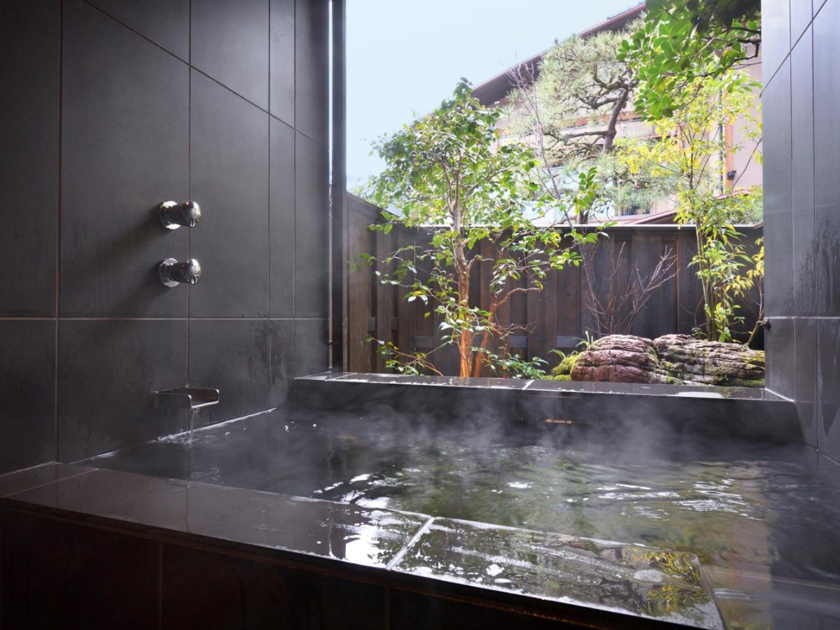 Private bath facing a courtyard garden in a villa at Oni no Sumika in Shuzenji