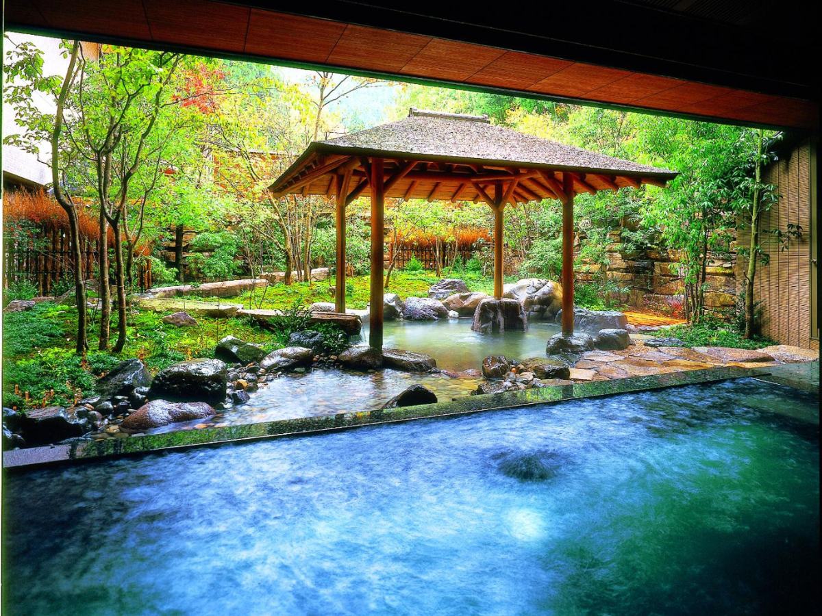 Open-air bath with a gazebo and stream at Nishimuraya Shogetsutei