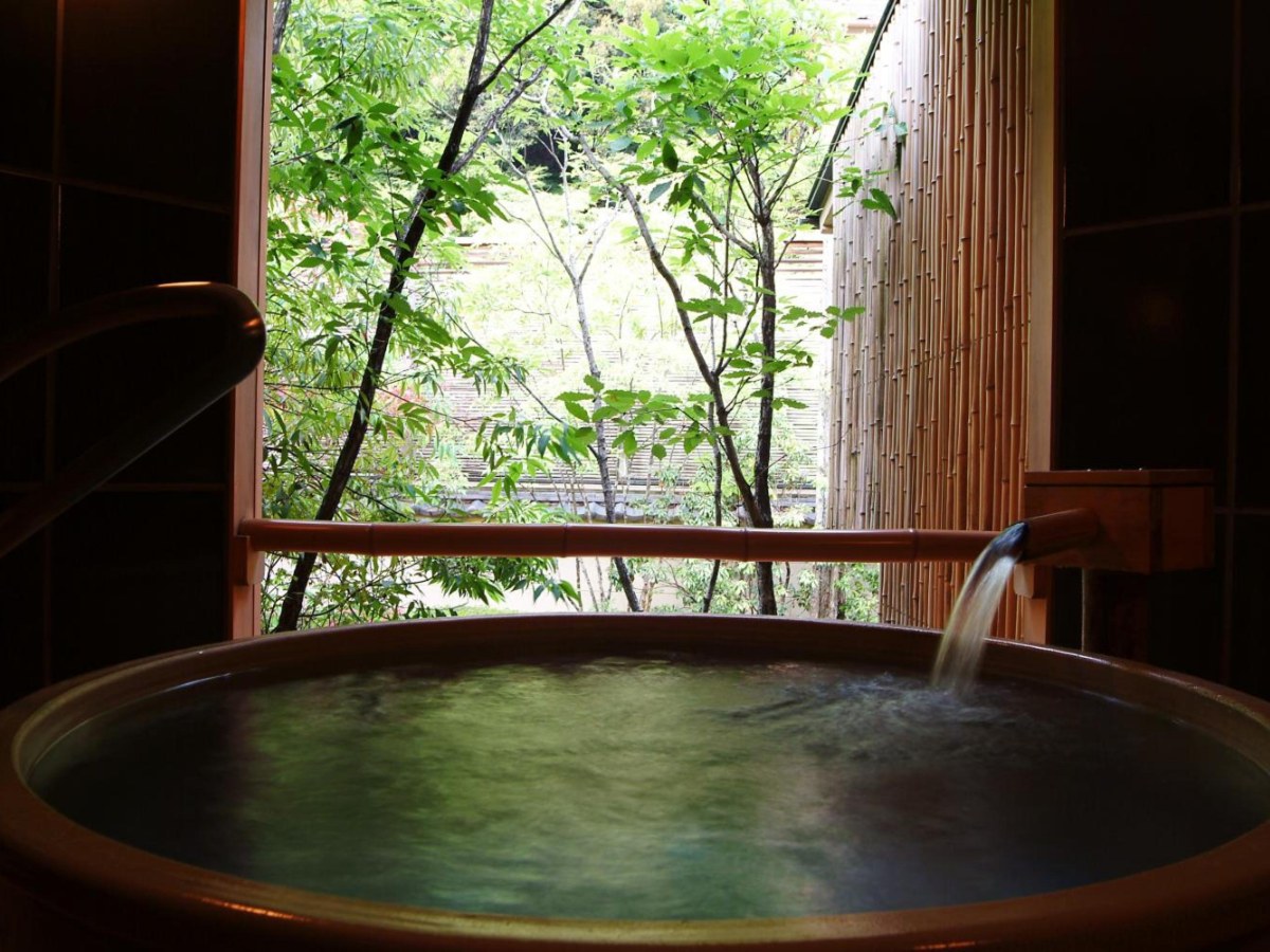 Round cypress bath tub with a water spout at Nishimuraya Honkan