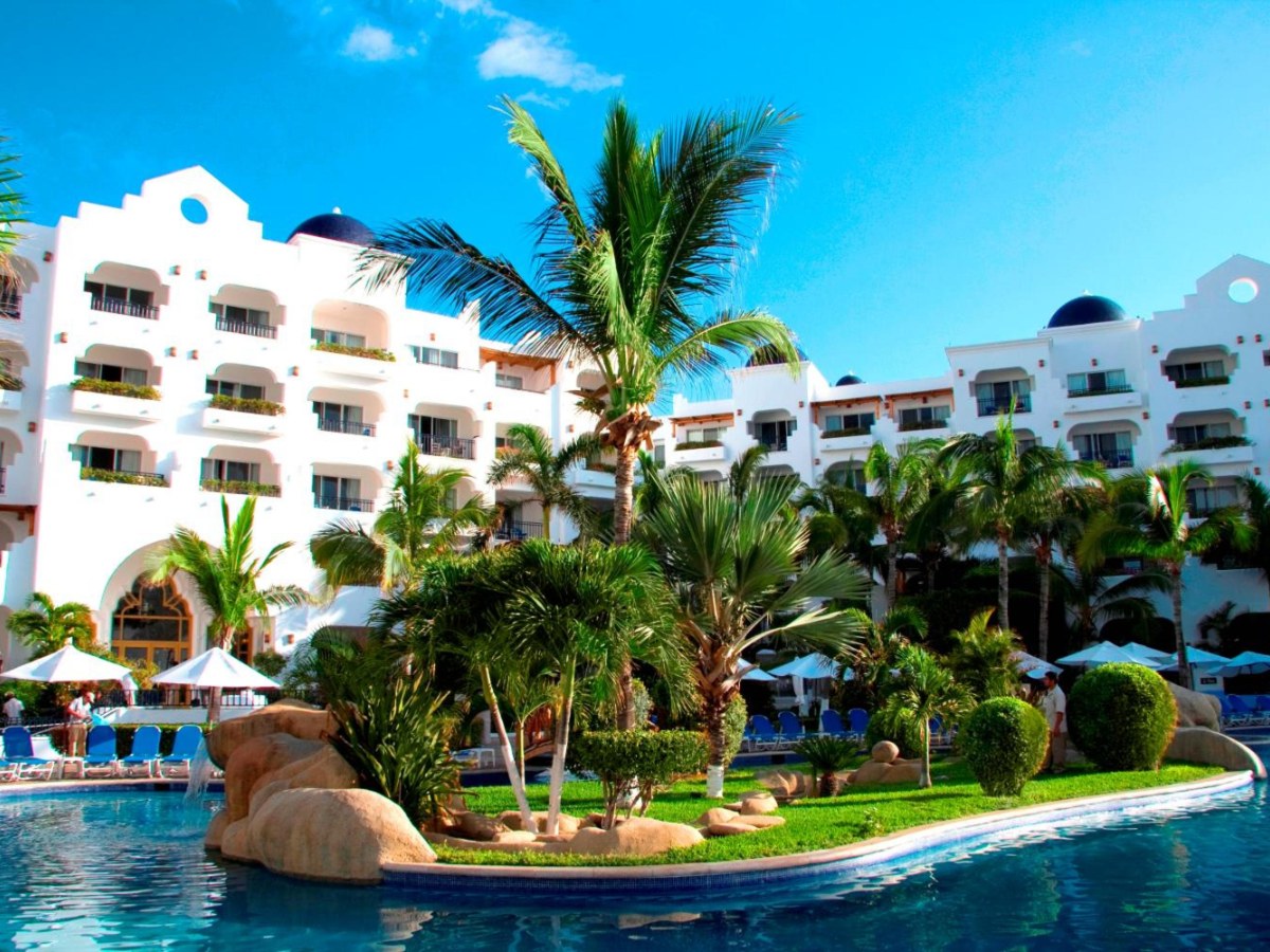 Resort pool with a rock island at Pueblo Bonito Blanco in Cabo San Lucas