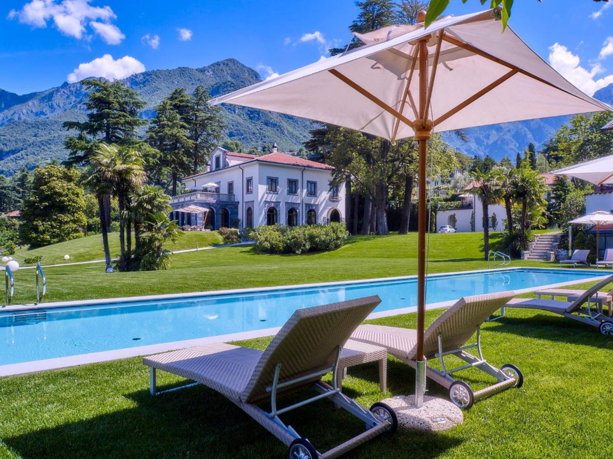 Pool lawn with lake and mountain views at Villa Lario Resort Mandello