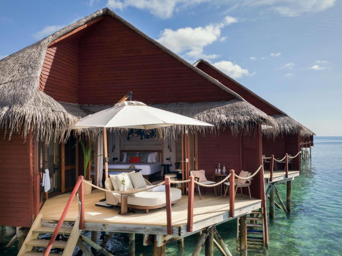Overwater villa with chairs and an umbrella at V Villas Maldives at Mirihi