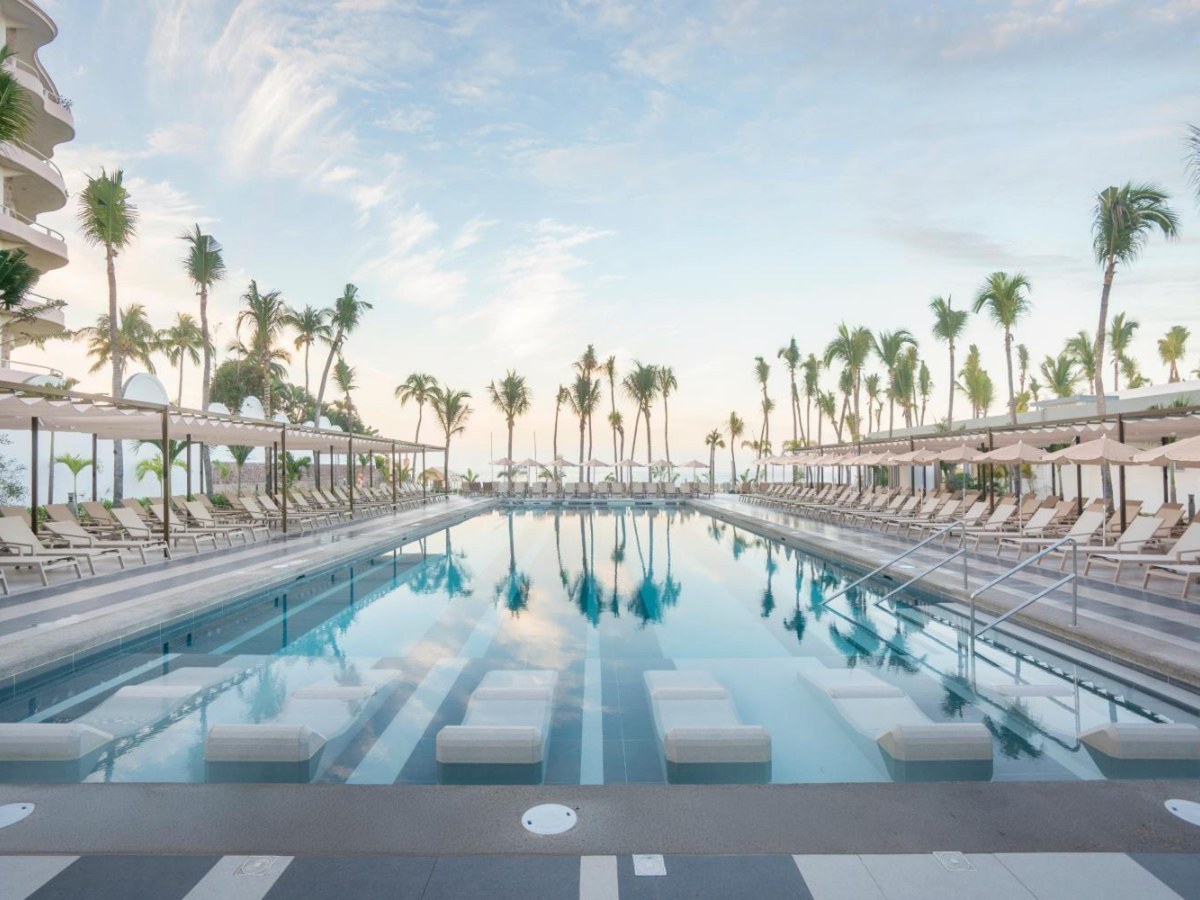 Long pool with loungers and palm trees at Riu Flamingos