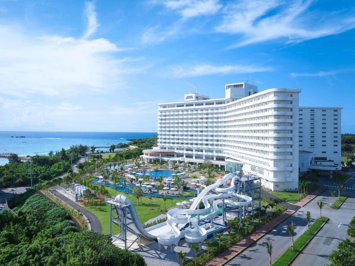Pool and water slides beside Grand Mercure Okinawa Cape Zanpa Resort with the sea beyond