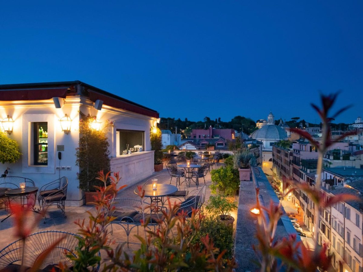 Hotel Locarno rooftop terrace at dusk over the rooftops of Rome