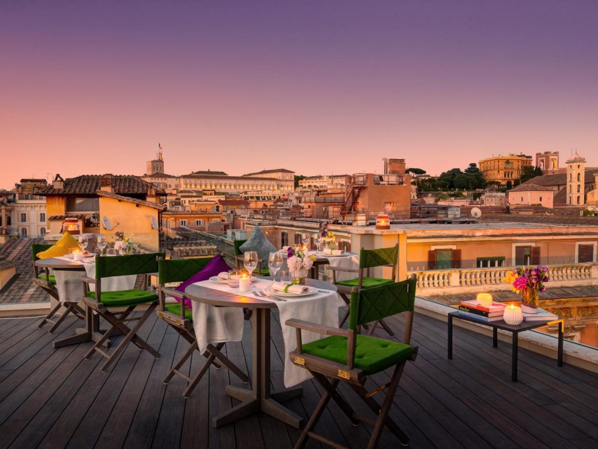 Singer Palace rooftop terrace with tables at sunset over Rome