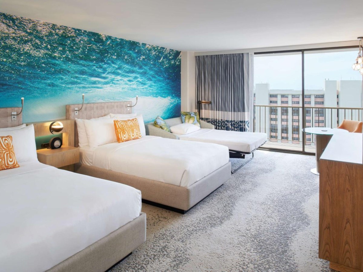 Two double beds and a sofa in an Outrigger Waikiki Beachcomber junior suite