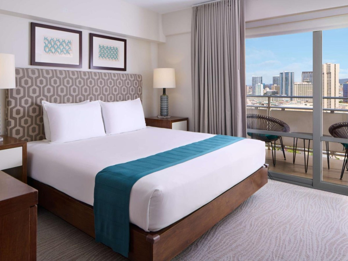 Large bed and balcony in an Ilikai Hotel two-bedroom suite