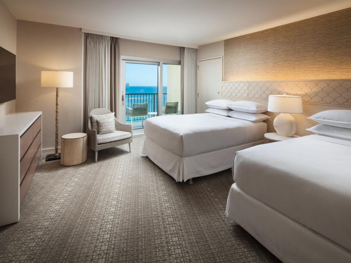 Two beds and a balcony in a Sheraton Waikiki Beach Resort guest room