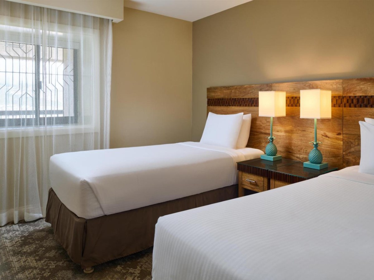 Two single beds in the second bedroom of an Aston Waikiki Beach Tower two-bedroom suite
