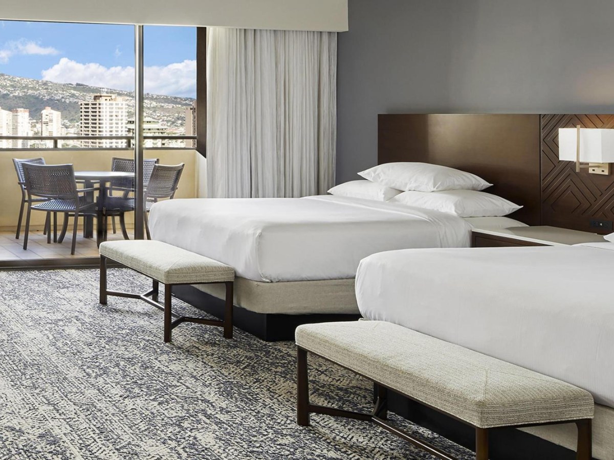 Two beds and a table in a Hilton Hawaiian Village Tapa Collection family room
